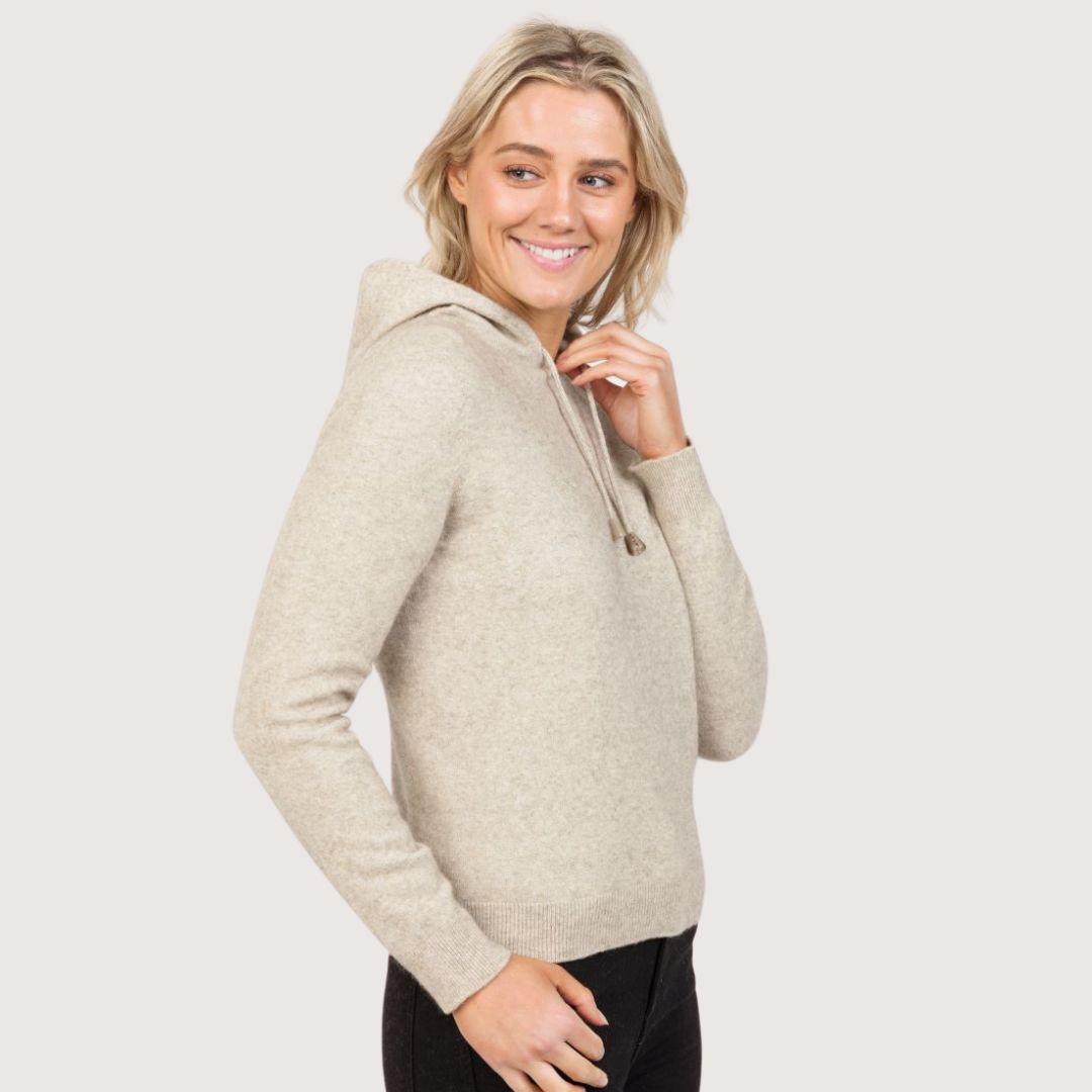 Model wearing a Natural beige cropped knitted hoodie, viewed from the side